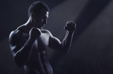 Man boxing. Young boxer fighter over black backgroundの写真素材
