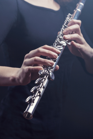 Close-up of a woman playing the flute. Studio shotの写真素材