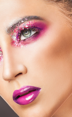 Fashion make-up. Close-up face of a beautiful sexy woman with pink fashion make-upの写真素材