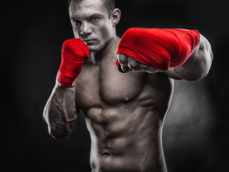 Close-up of a boxer's hand ready for a fight. Strong hands and clenched fists in red strapsの写真素材
