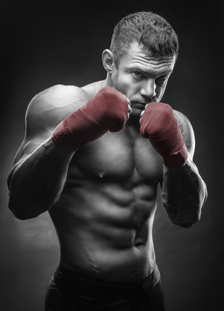 Close-up of a boxer's hand ready for a fight. Strong hands and clenched fists in red strapsの写真素材