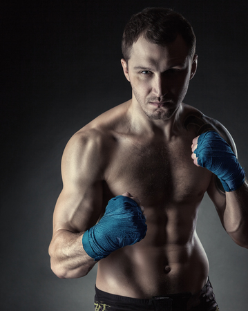 Boxer with bare chest is ready for fight. Concept. Strong arms and clenched fistsの写真素材