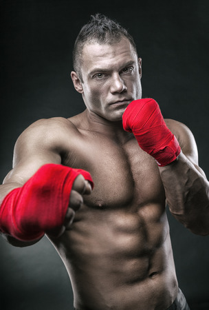 Close-up of a boxer's hand ready for a fight. Strong hands and clenched fists in red strapsの写真素材