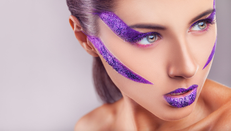 Close Up of a glamour portrait of beautiful woman model with bright purple makeupの写真素材