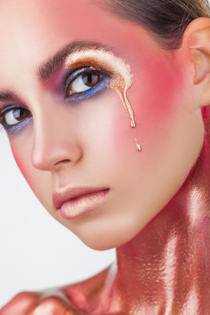 Glamour portrait of beautiful woman model with bright pink make-up with golden dripping drop. Fashion make-upの写真素材