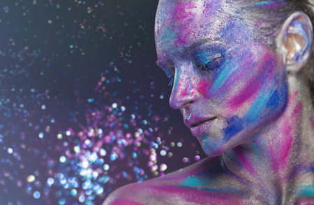 Fantasy makeup. Woman with colorful makeup and body art against dark background with sequins. Fashionの写真素材