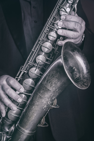 Saxophone player jazz music instrumental. Alto sax musical instrument close up. Black and white imageの写真素材