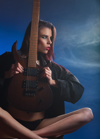 Young attractive girl posing with an electric guitar. Studio shotの写真素材