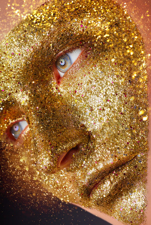Fashion makeup. Beautiful young woman with golden makeupの写真素材