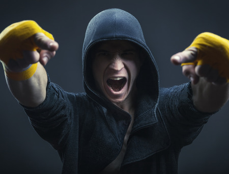 Boxer man in the hood is pointing fingers at youの写真素材