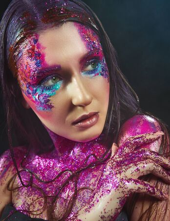 Portrait of a beautiful fashion model woman with sparkles on her face and bodyの写真素材