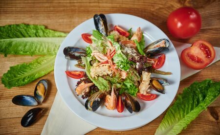 Delicious healthy salad with shrimp, mussels, tomatoes and lettuce leaf, close-upの写真素材