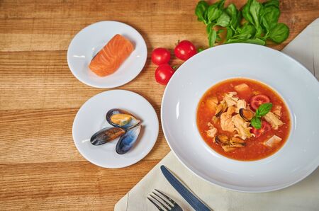 Sicilian tomato seafood soup. Soup with mussels and fish. Beautiful dish. Arrangement with cutleryの写真素材