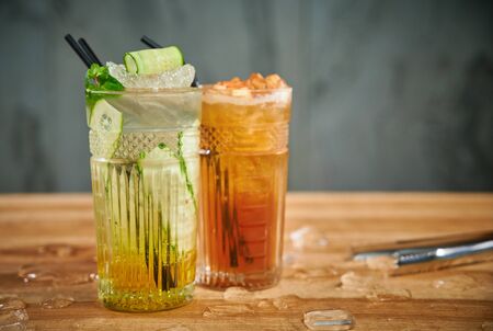 Two glasses with refreshing drinks. Delicious refreshing waters with cucumber and cinnamon in glassesの写真素材
