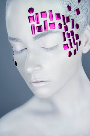 High fashion model. Woman with white makeup and accessories. White skin make-up. Art design makeupの写真素材