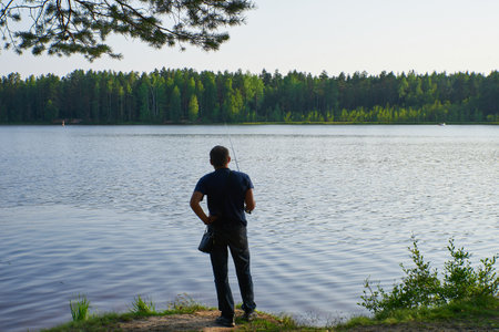 a fisherman catches fish in a lake without waves and a calm windの写真素材