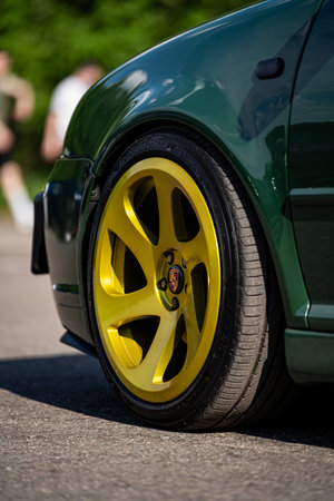 Closeup of rear wheel of green sport car parked in the streetの写真素材