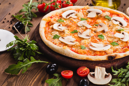 italian pizza with chicken and mushrooms on the wooden dark background (close).の写真素材