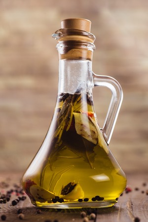 Olive oil on a dark wooden background (close)の写真素材