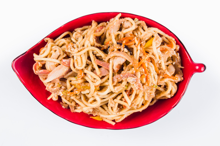 noodles with bacon and pepper on a red plate on a white background. Traditional Italian pasta. Close top viewの写真素材