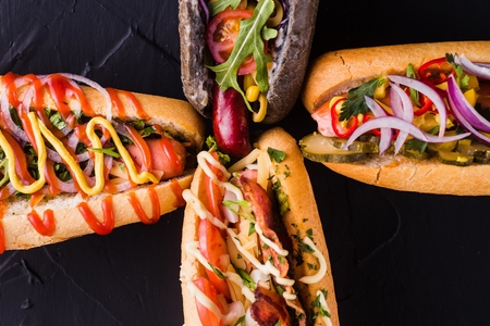 Four hot dog on a dark background (close top view)の写真素材