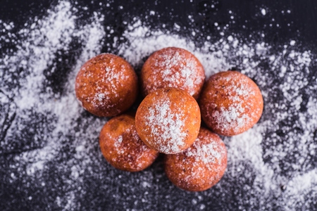 Curd balls sprinkled with sugar buds on a dark background (close top view)の写真素材