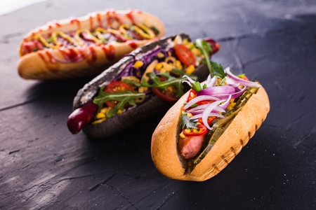 three hot dog on a dark background (close)の写真素材