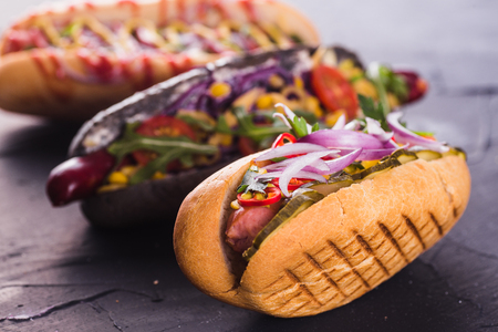 three hot dog on a dark background (close)の写真素材
