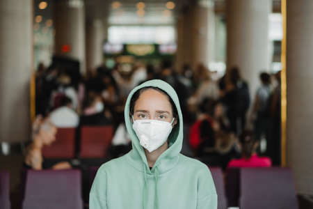 Virus mask woman travel wearing face protection in prevention for coronavirus in Asia. Girl waiting boarding in a public airport space .の写真素材