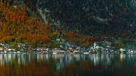 Panoramic view of the mountain village in the Austrian Alps. Autumn Landscape. Hallstatt, Austria. Blue sky and mountains. Beautiful and cozy town. Postcard concept. Hallstatter lake with reflections.の写真素材