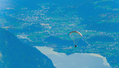 Beautiful mountain view with paraglider near Hallstatt village, Austria. Paragliding and parashuting in Alps. Beautiful perspective view of rocks range.の写真素材