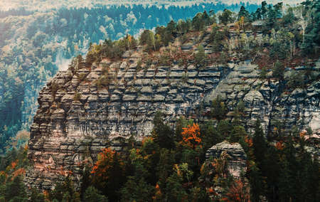 Mountains and cliffs similar to peoples faces. Beautiful shot of the rocks and trees. Czech Republic location. Postcard concept. Autumn seasonal forest.の写真素材