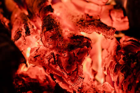 The tree is on fire. Close-up of coals in the stove. Texture and structure of a hot tree logs. Red colour and high temperature. Coal preparation for bath and barbecue. の写真素材