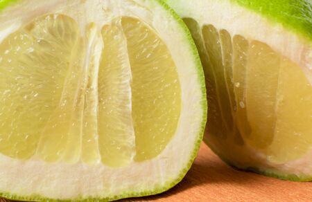 fresh organic green grapefruit on the orange backgroundの写真素材