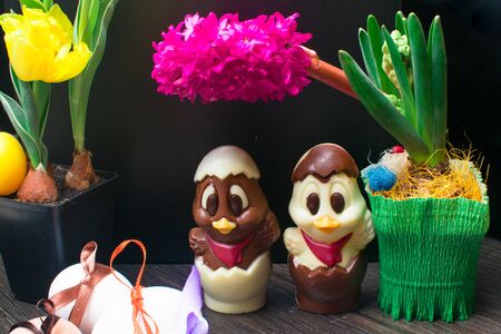 easter eggs with color ribbon and chocolate cute chicken decorated with flower - tulip and geocint on black backgroundの写真素材