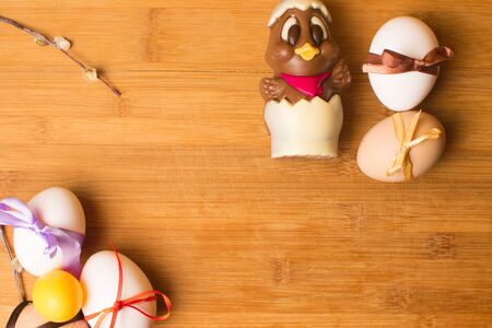 easter eggs with color ribbon and chocolate cute chicken on the orange background, april holiday