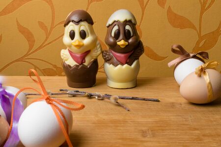 easter eggs with color ribbon and chocolate cute chicken on the orange background, april holiday