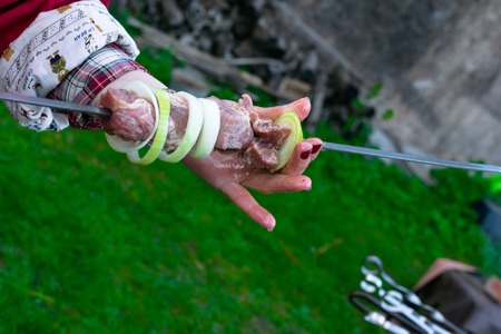 Grilled kebab cooking on metal skewer. Roasted meat cooked at barbecue. BBQ fresh beef meat chop slices. Traditional eastern dish, shish kebab. Picnic, street food. Roasting meat on a spitの写真素材