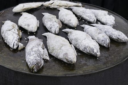 Cooking fried fish smelt rolled in flour