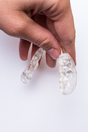 Inivisalign braces or aligner in hand. A way to have a beautiful smile and white teeth.