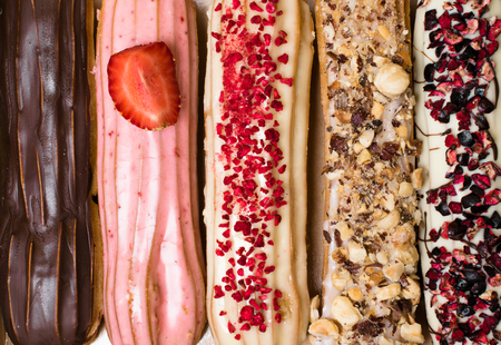 Sweet delicious colorful french eclairs. Group of french dessert. Eclair background. French pastry...