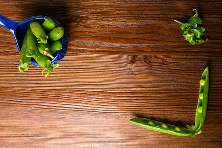 Bunch of mature pods of green peas on the old wooden background. Bio healthy food. Selective focus. Copy space backgroundの写真素材