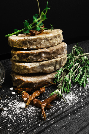 Raw Minced burger Meat with Herb, Spice, Salt Prepared for Grilling with rosemary, hot red chili, black pepper on black wooden tableの写真素材