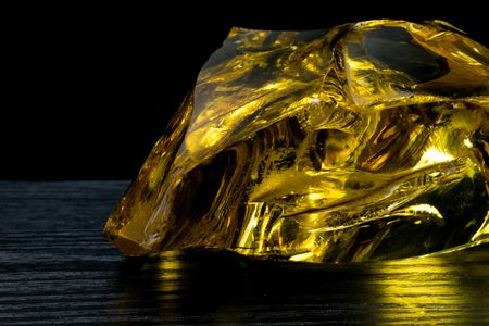 Beautiful big piece of amber on a black background. Sun stone. Petrified resin is a natural crystal material for jewelry. Vintageの写真素材