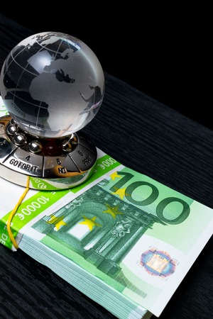 glass earth with choice and big amount euro cash 500, 100 on the black wooden backgroundの写真素材