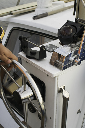 captain at the sailing yacht helm, control wheel