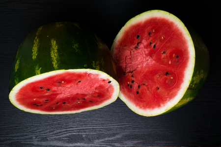Delicious watermelon cut in halves isolated on black background with clipping pathの写真素材