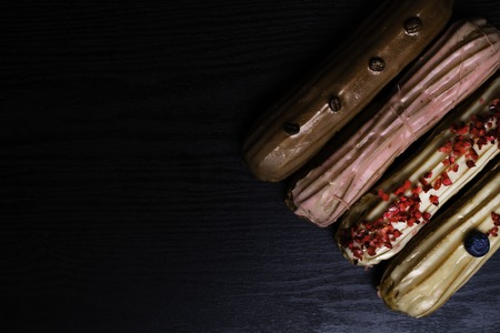 French traditional eclair, decorated with raspberry, blueberry,cream and coffee beans