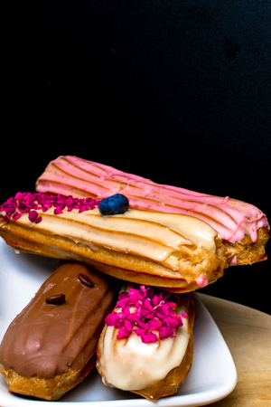 French traditional eclair, decorated with raspberry and creamの写真素材