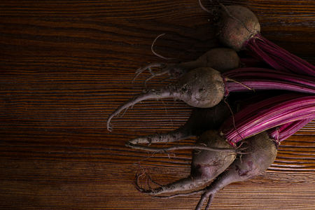 Red organic bunch Beetroot with herbage green leaves with foliage, on wooden backgroundの写真素材